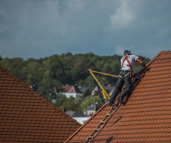 Dachdecker mit Kappe auf Dach