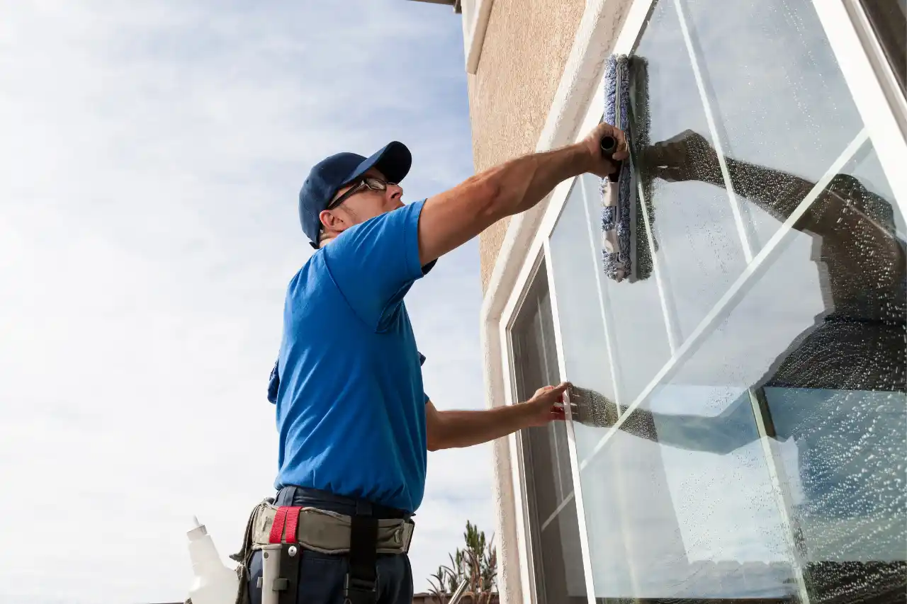 Glasreiniger mit Abzieher reinigt eine große Fensterfläche von außen