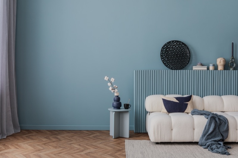 Moderner Wohnraum mit professionell gestrichener blauer Wand und weißem Sofa - Qualitätsarbeit von Goldkraft Malerbetrieb Karlsruhe