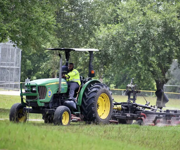 Landschaftsbauer fährt auf Traktor