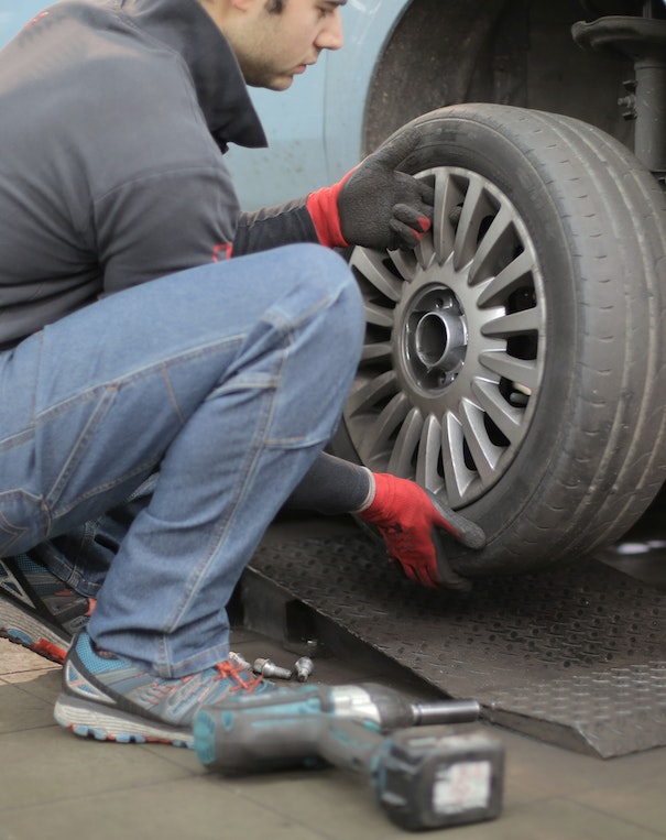 Mann wechselt Autoreifen