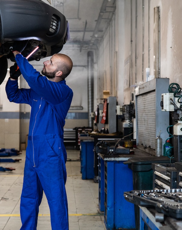 Zu sehen ist eine Autowerkstatt, in der ein Mann gerade am arbeiten ist