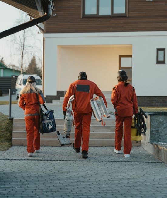 Drei Reiniger bewegen sich auf ein Haus zu